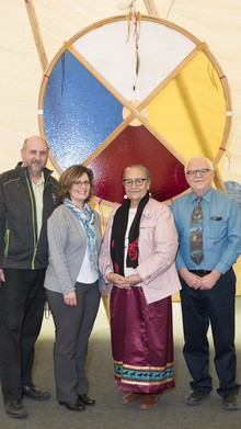 (Left to Right) St. Augustine Principal Kevin Prediger, STAR Catholic Board Chair Michelle Lamer, Elder Ida Bull, and Nipisihkopahk Education Authority (NEA) Superintendent Kevin Wells stand with a Medicine Wheel handcrafted by Prediger and gifted to NEA